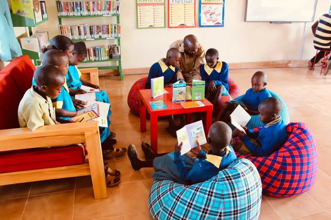 a group of children sitting in a circle reading books